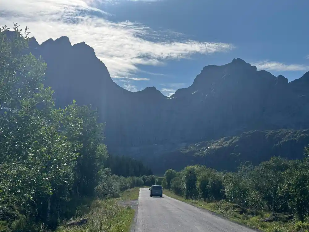 Car on road through valley between steep mountains