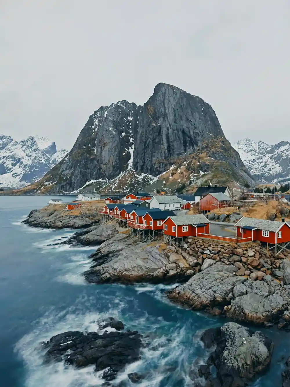 Colorful fishing buildings nestled below twin rocky peaks
