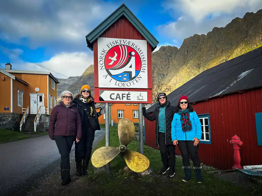 Five people standing by cafe sign with giant wooden spoon
