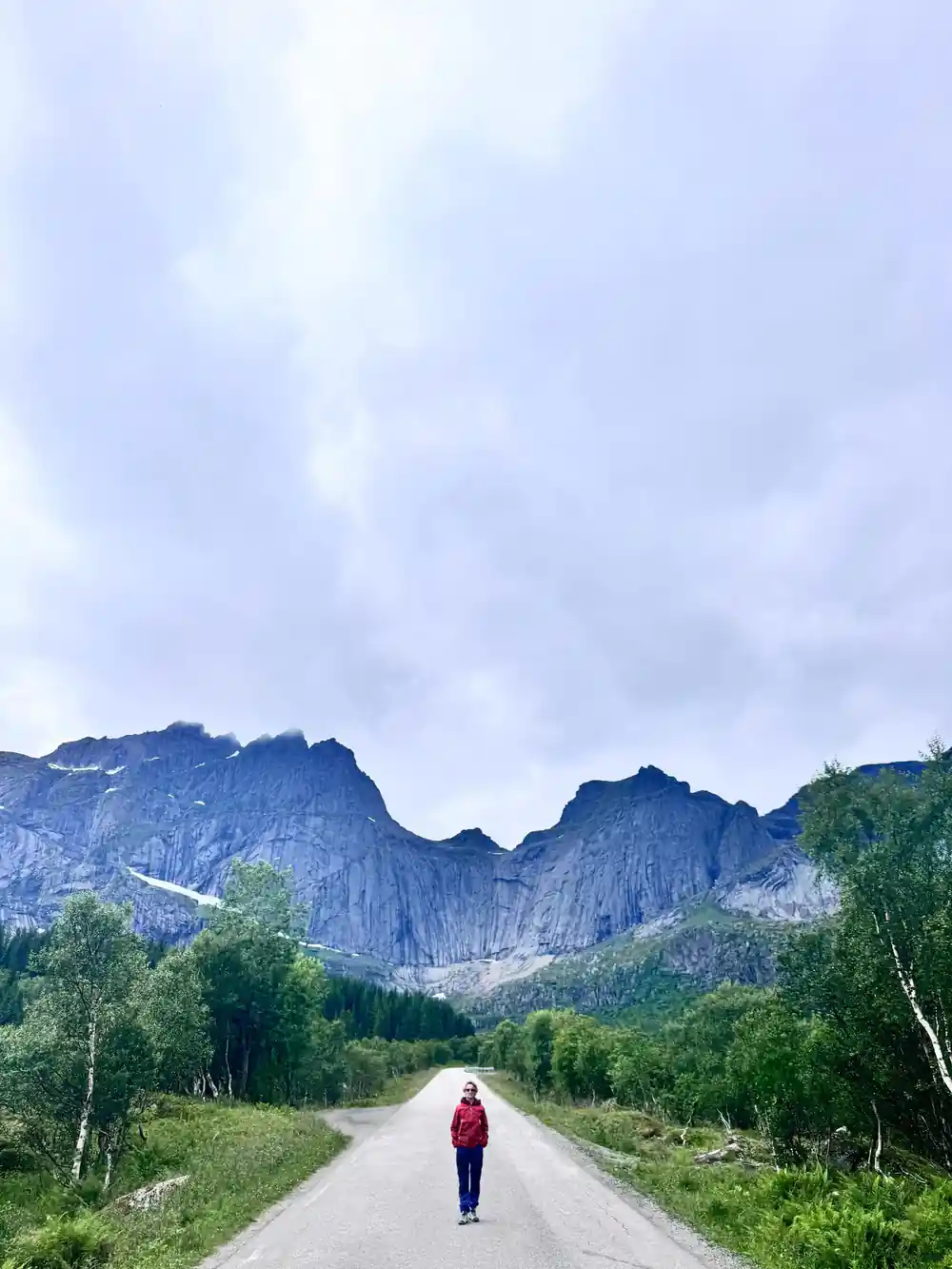 Person walking on straight road toward distant mountains