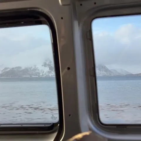 Snowy Lofoten peaks seen through a minivan window