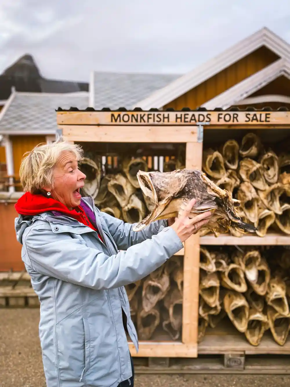 Woman holding dried monkfish head at souvenir stand