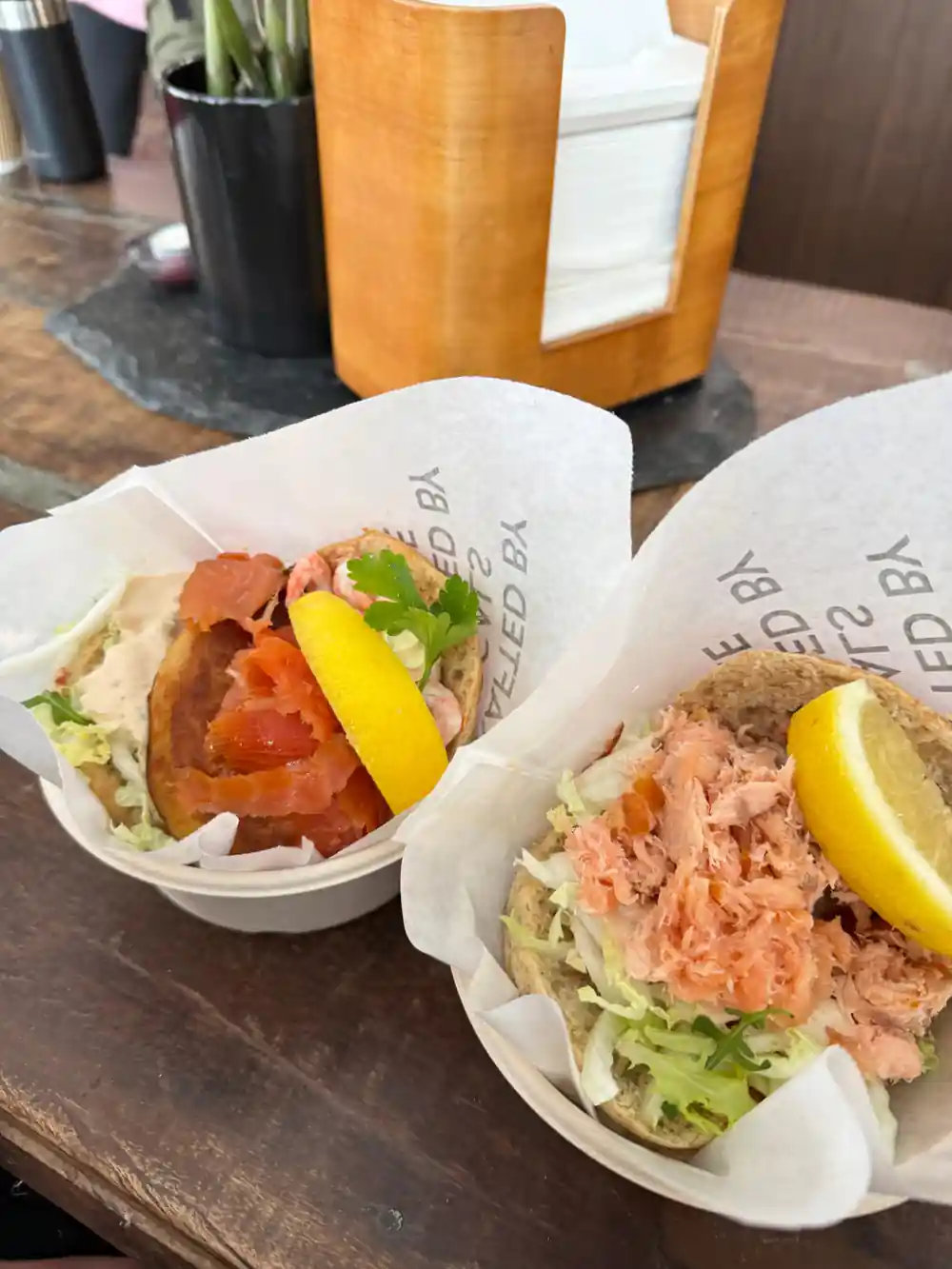 Wrapped seafood wraps with lemon wedges on counter