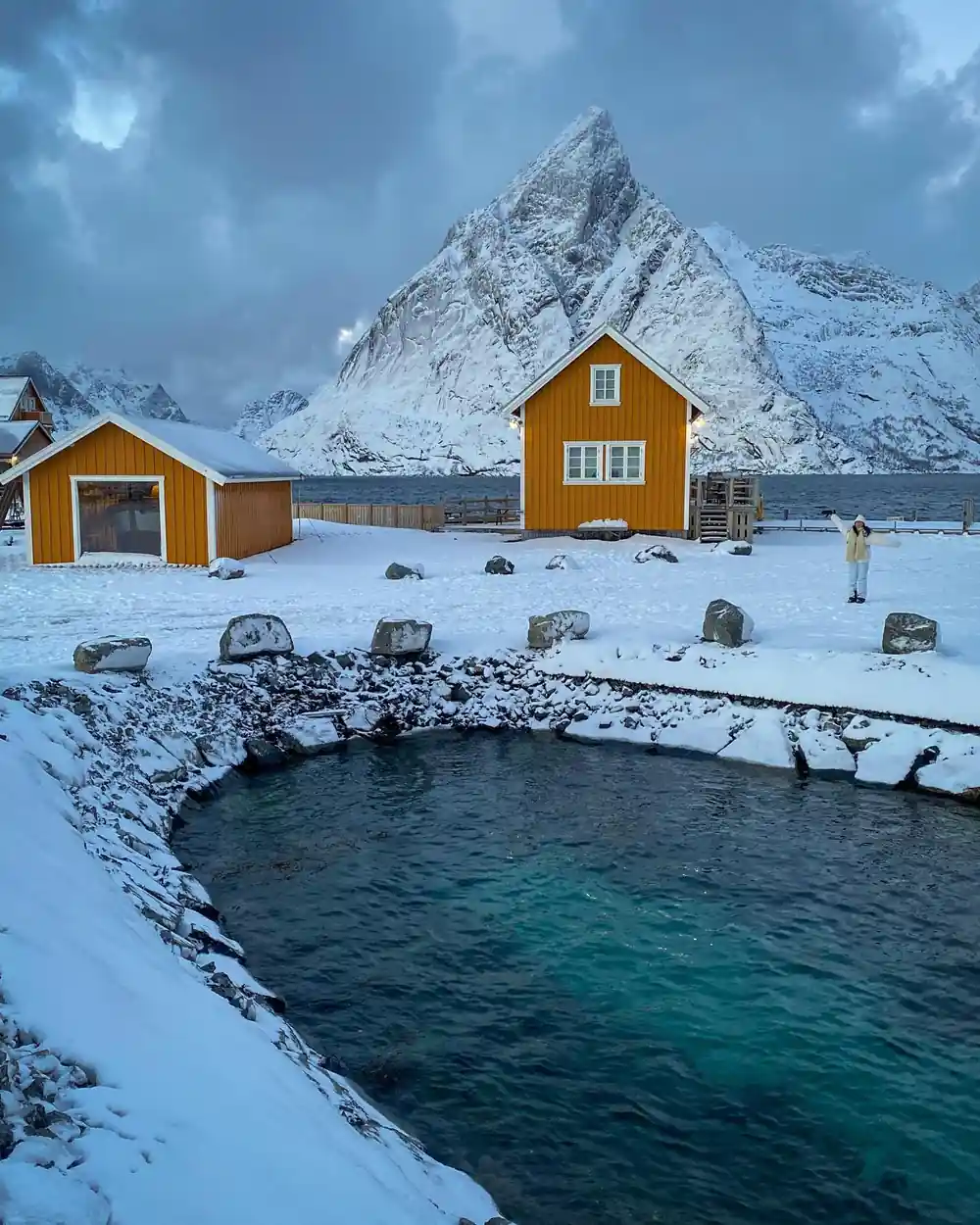 Yellow houses by geothermal hot spring pool in snow